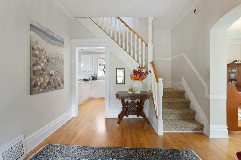 the interior of a white house with wood floors and stairs