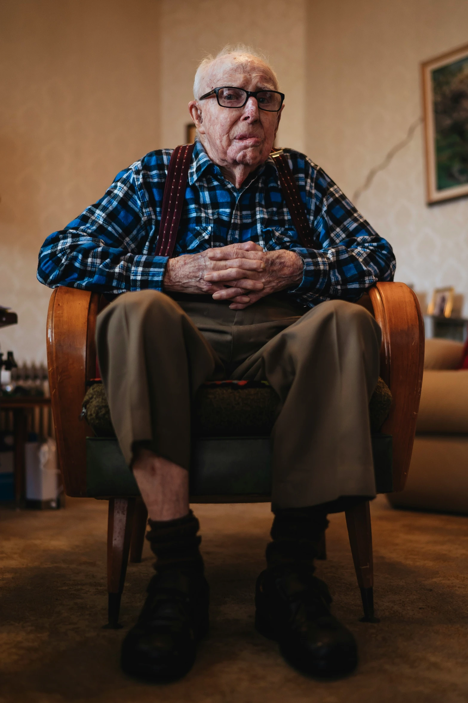 an old man sitting on a chair in his living room