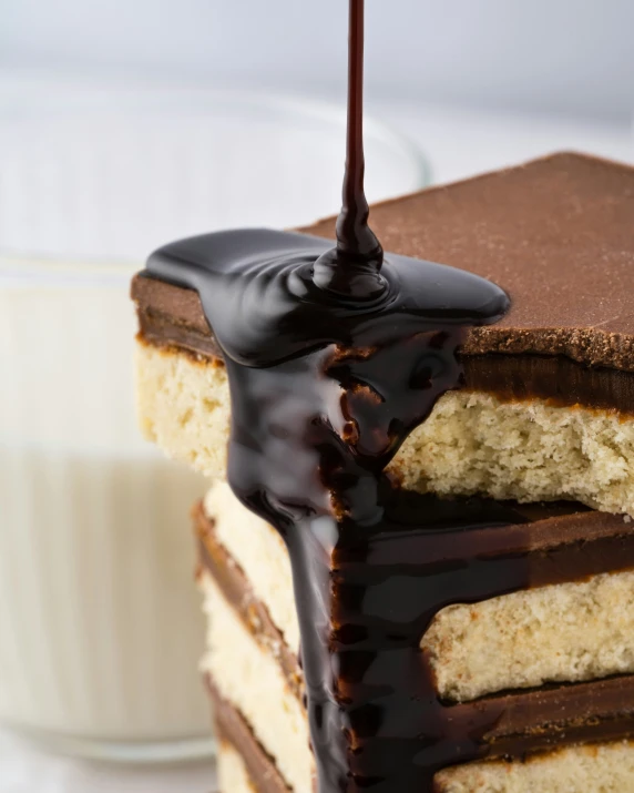 a slice of chocolate covered cake and a glass of milk