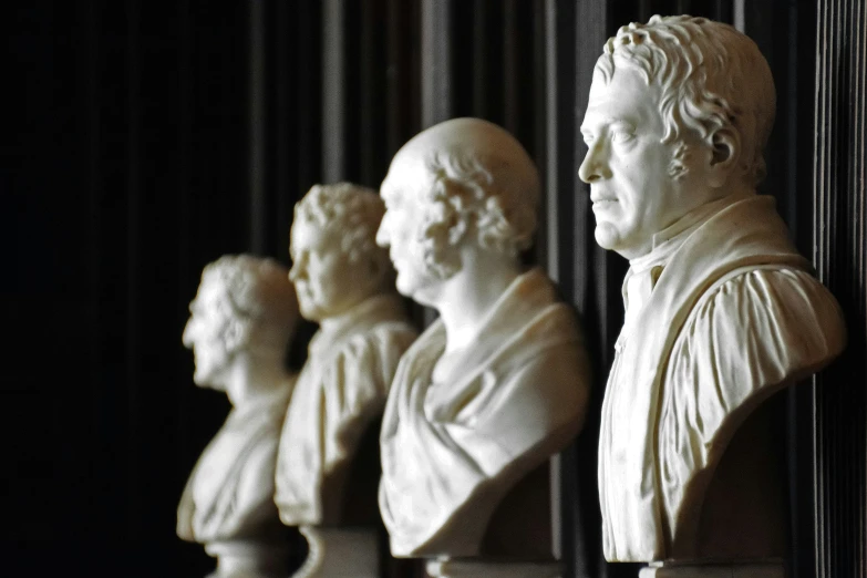 marble busts line up on the wall of a building