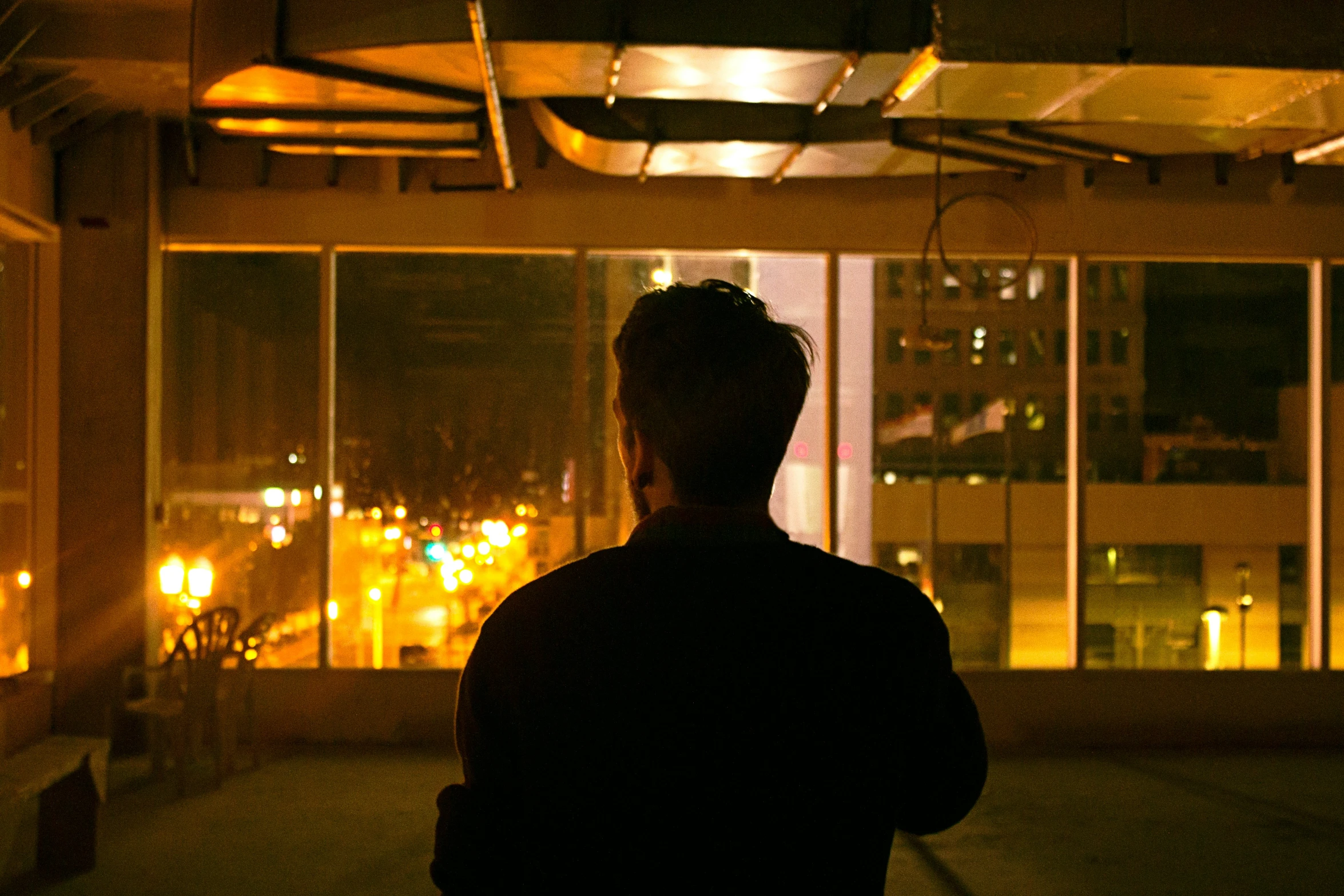 a man standing in front of window looking outside