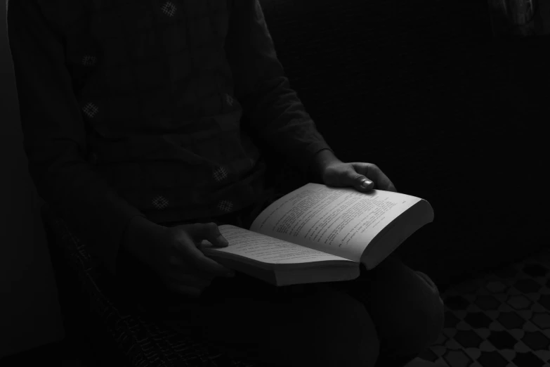 a person holding an open book in their hands