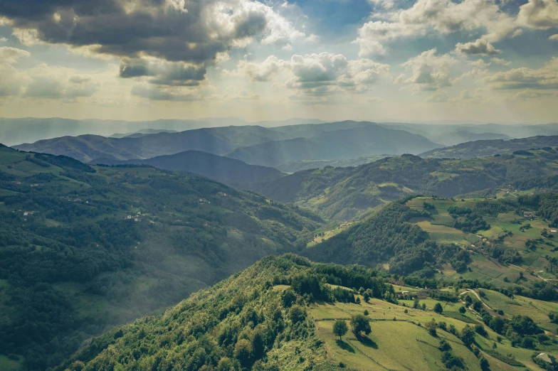 a grassy mountain area has blue sky above it