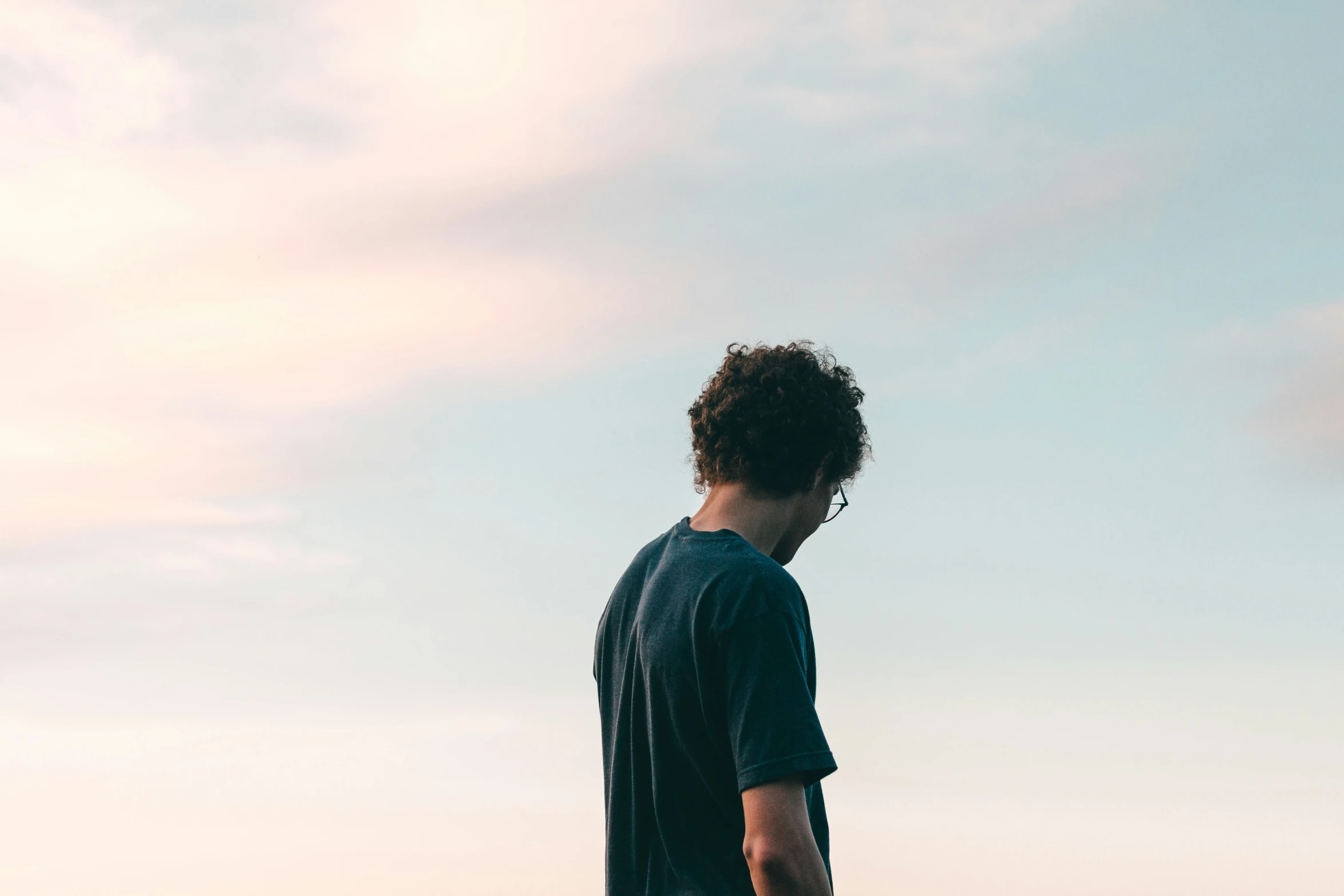 a young man standing on the beach in the sun