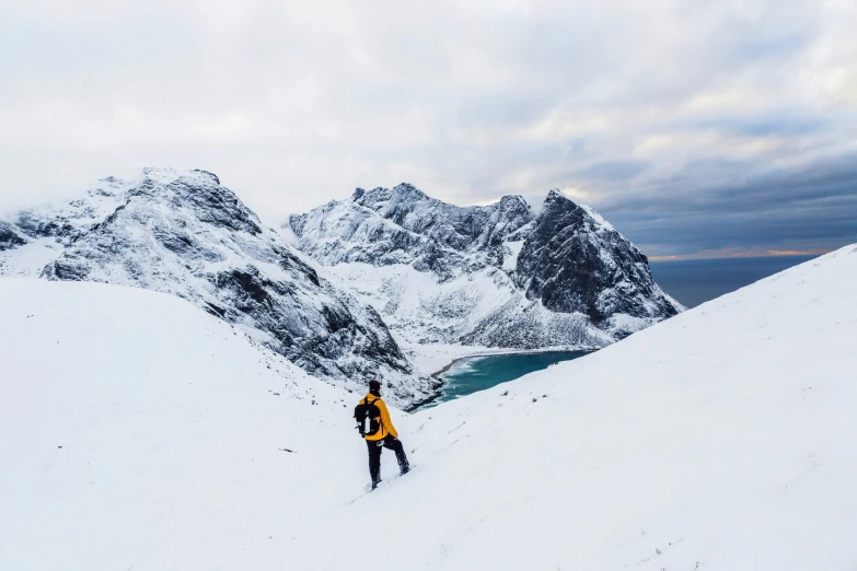 a person skis along the side of a snow covered mountain