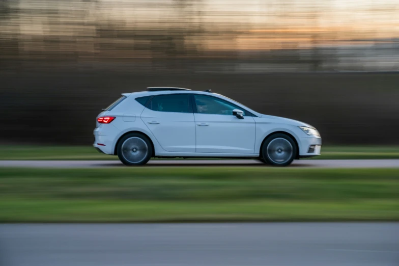 a white car is driving down the street