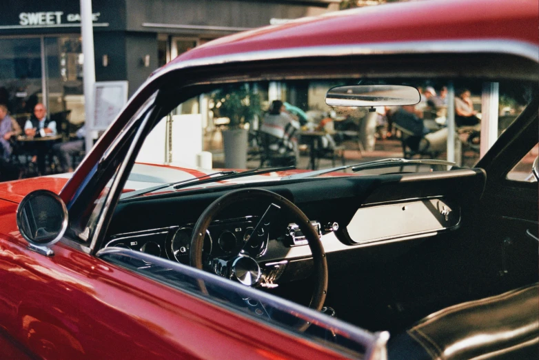 a classic car's dashboard is seen in front of another old car