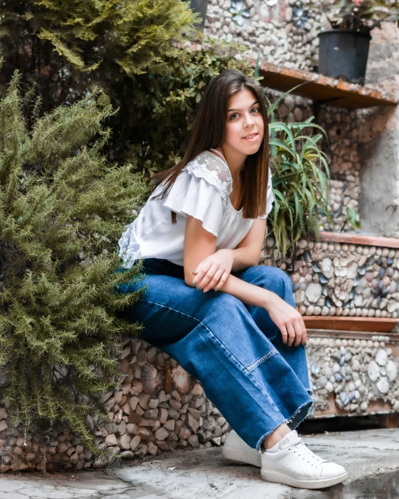 a woman is squatting in front of potted plants