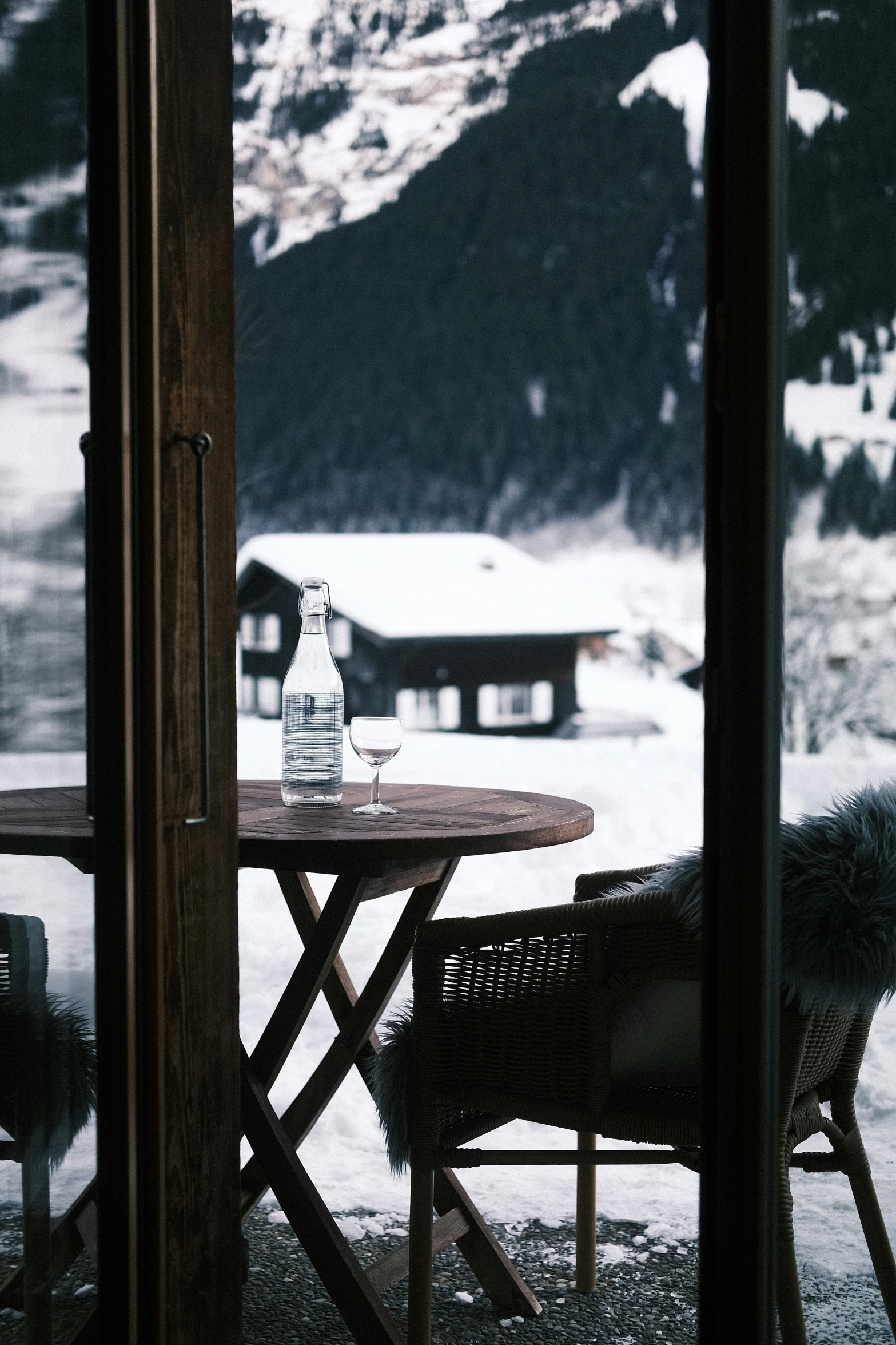 table in front of mountains with wine bottle on it