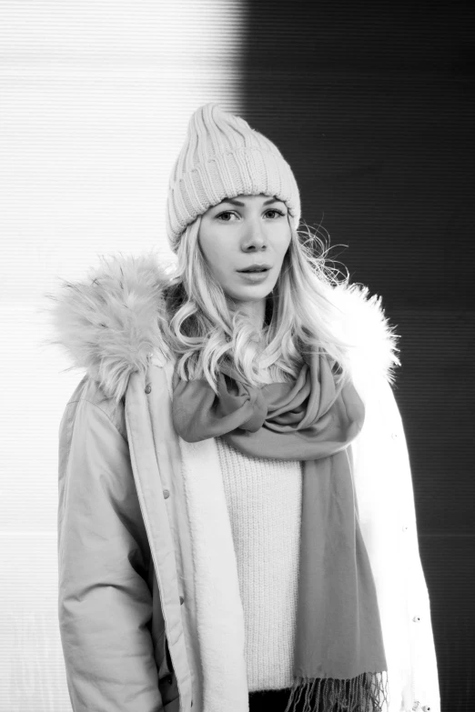 a woman standing with a scarf and jacket over her