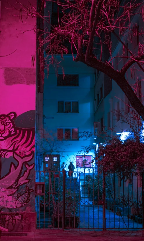 a neon - colored building on a dark street at night