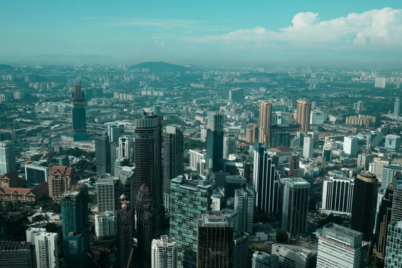 aerial view of city with skyscrs and mountains in the distance