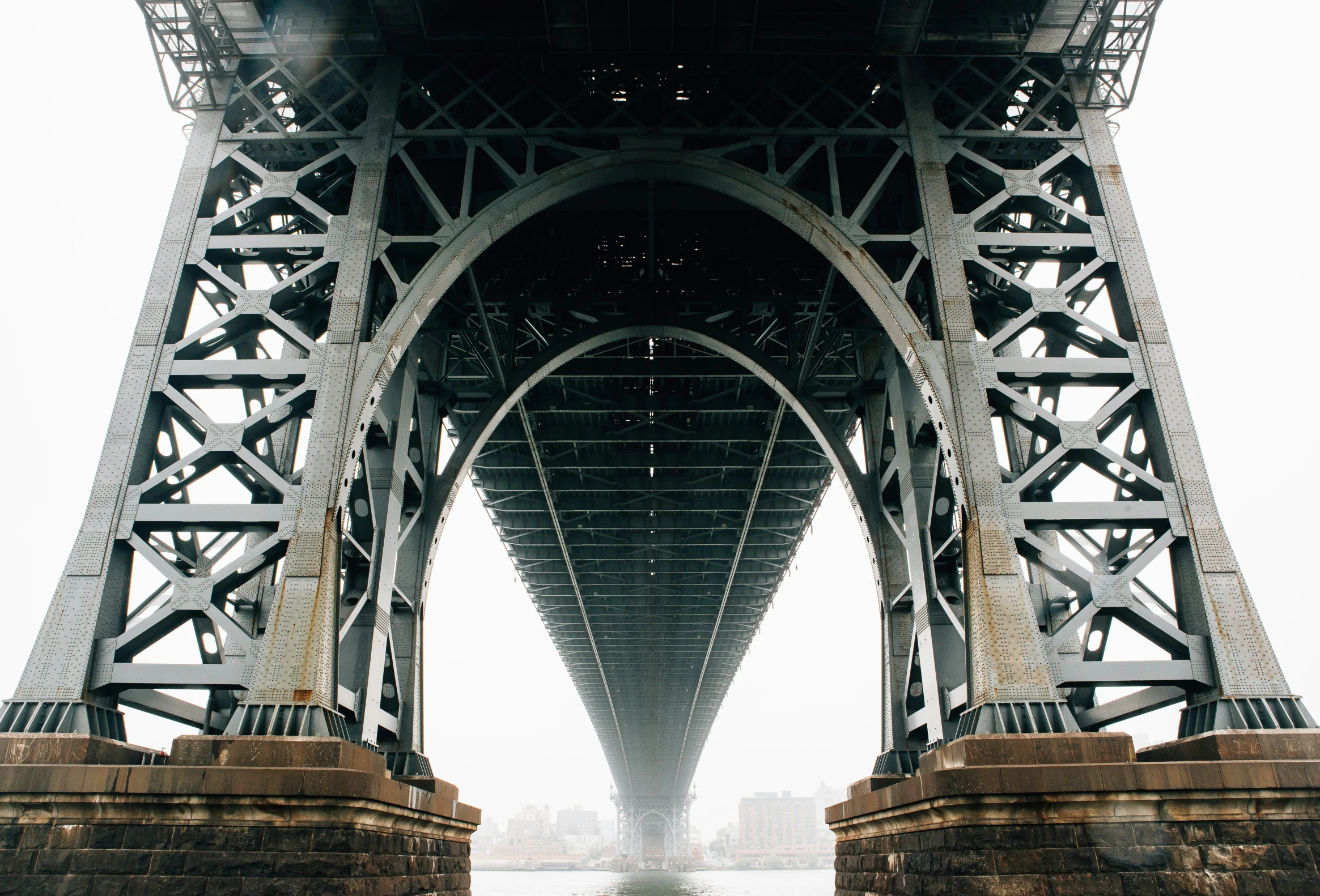 the underside of an old metal bridge over water