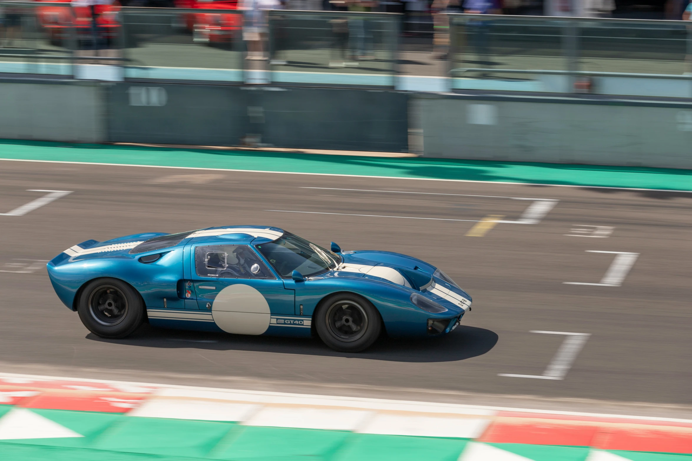 a very blue race car driving along a track