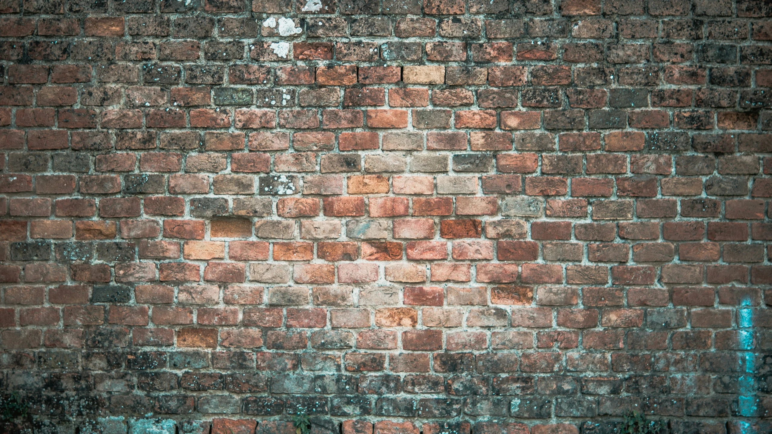 a brick wall with a faded yellow stop sign