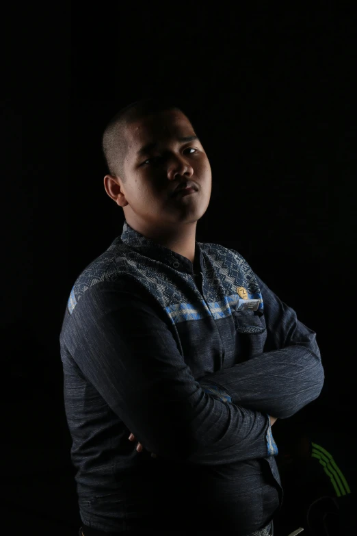 a man in a black shirt posing with his arms folded