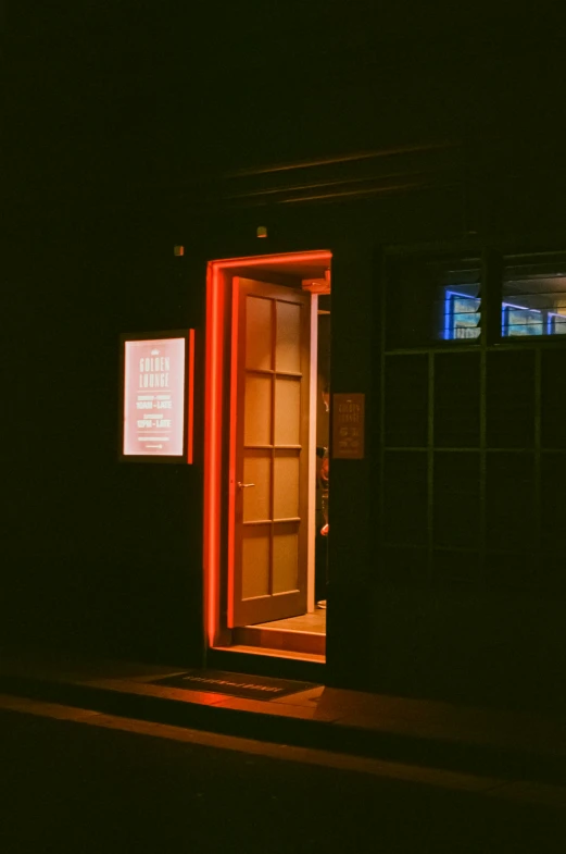the open door of the building is illuminated by red lighting