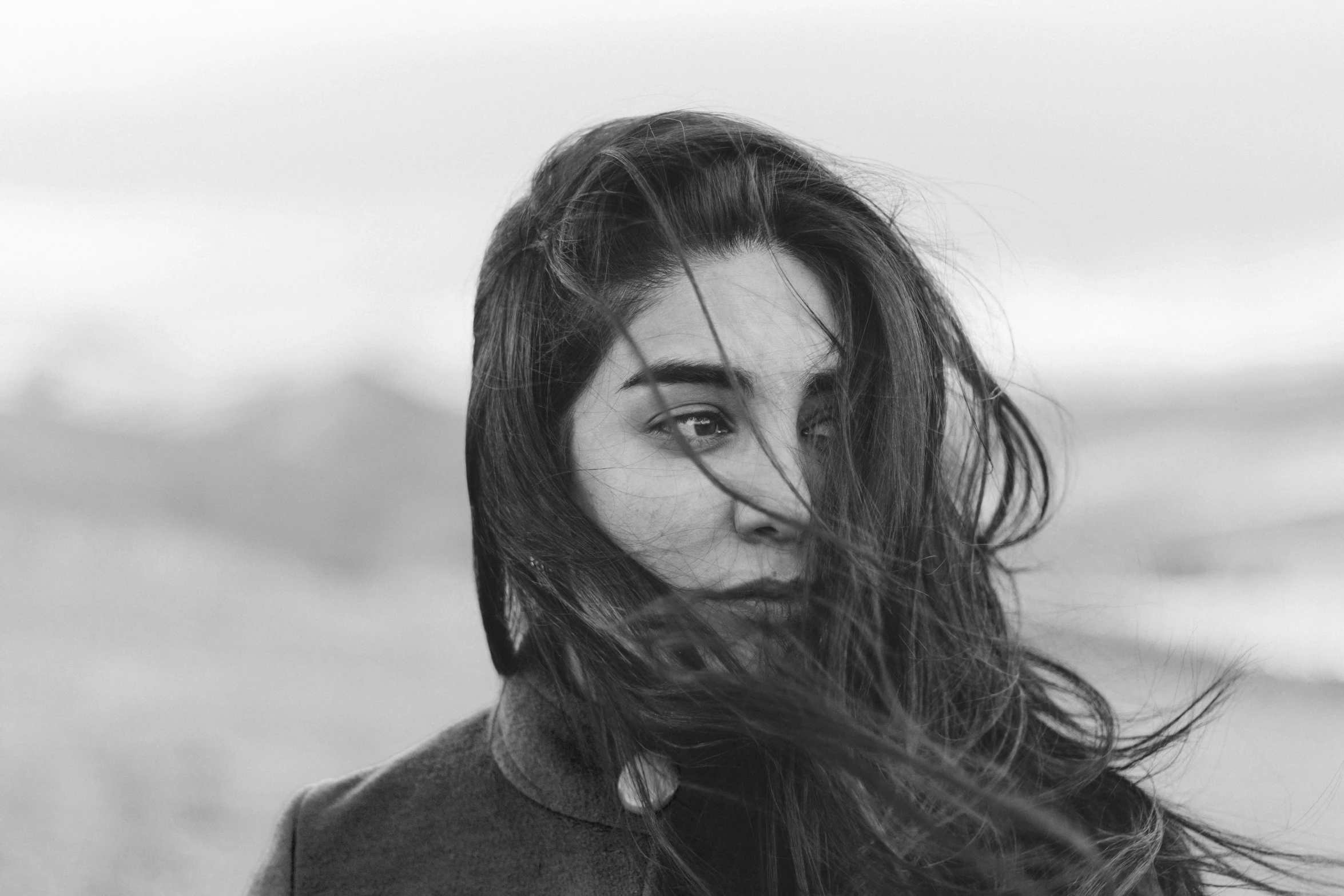 a woman standing in the wind while she has her hair blown