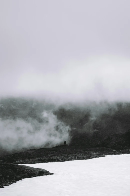 there is snow flying over a snowy hill