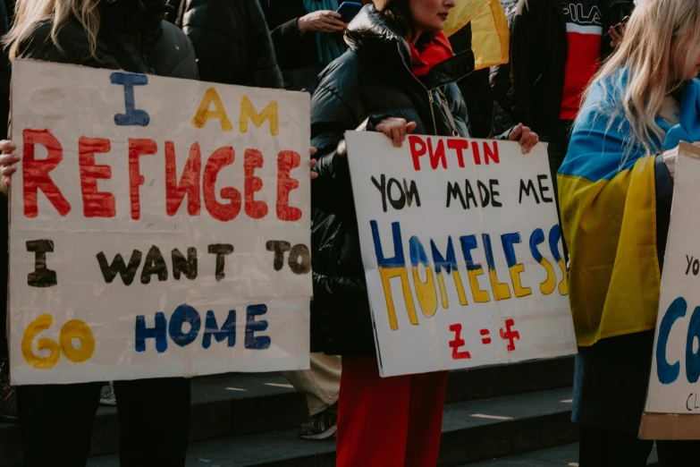 a group of people with signs in protest of homelessness