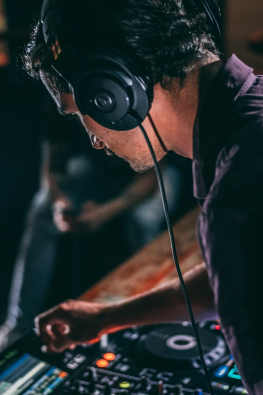 a man in headphones looking at the music playing on his dj equipment