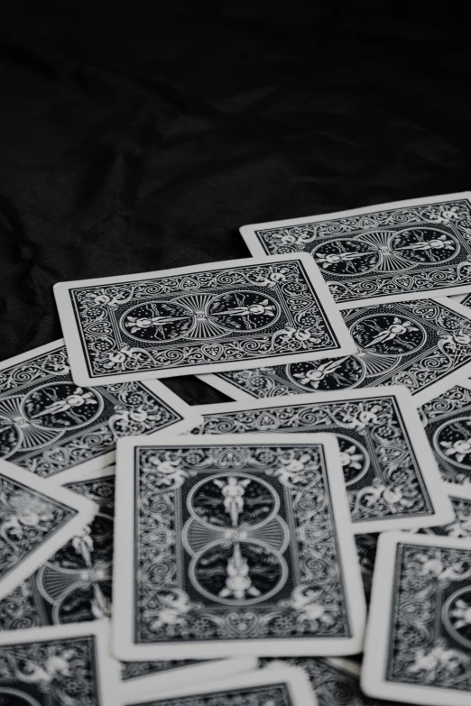 playing cards scattered out on a table with black cloth