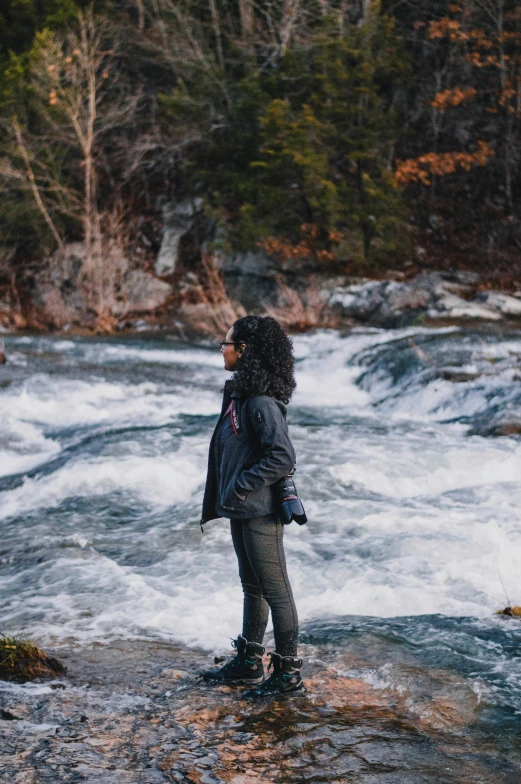 a person standing on a river bank looking at water