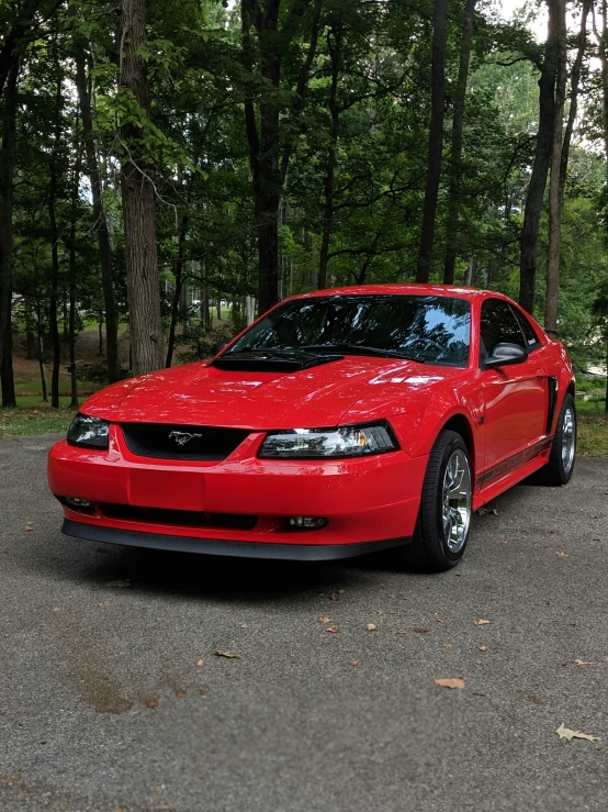 the red car is parked on the side of the road