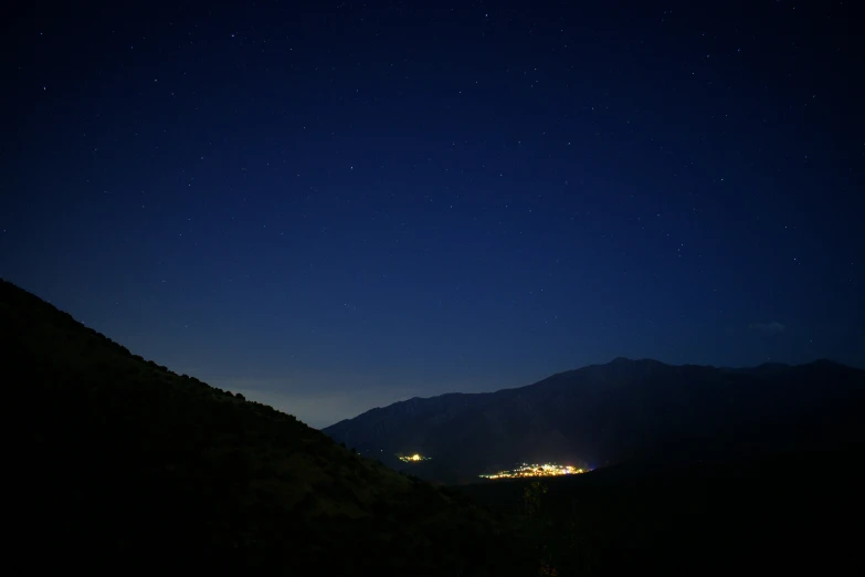 the night sky above a mountain range as seen from below