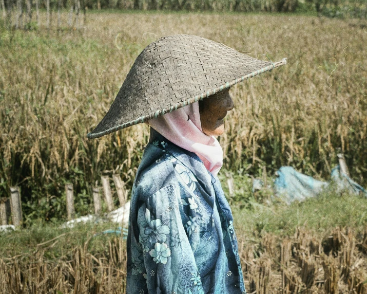 the woman in the straw hat is walking down the street