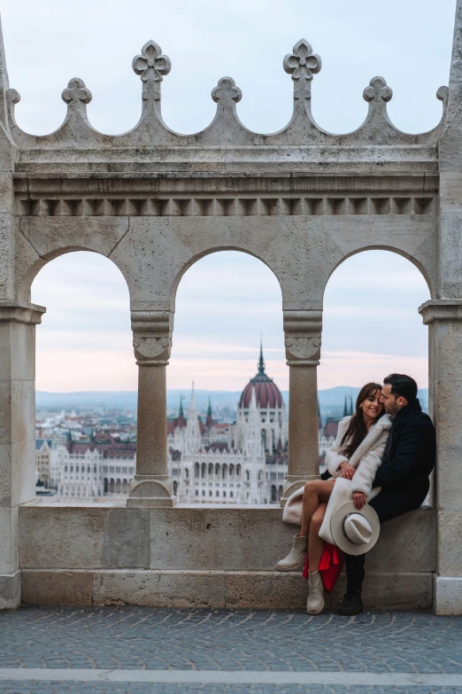 a man and woman sit next to each other with a view of a city