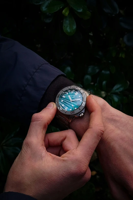 a man holds his watch while sitting in the sun