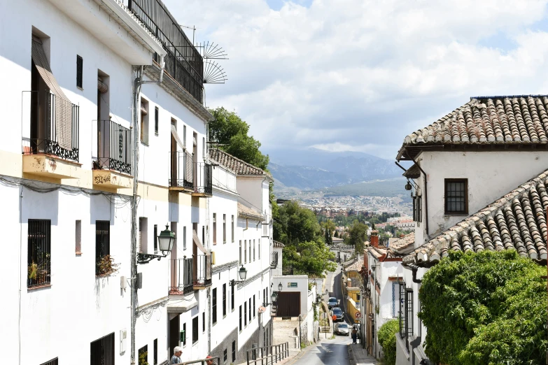 an alley way in a small village with mountains in the distance