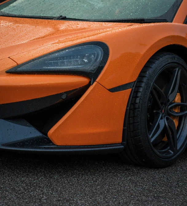 an orange sports car that is very shiny