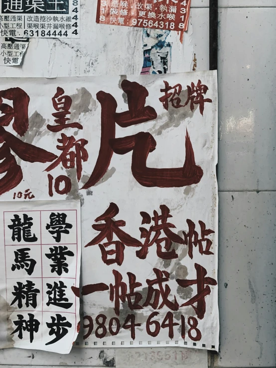 signs with chinese lettering and symbols hang on a building