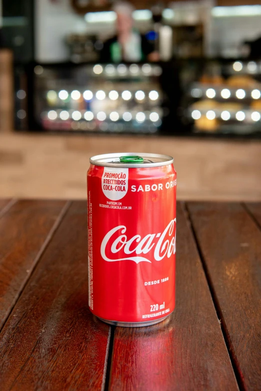 a can of coca cola sitting on top of a wooden table