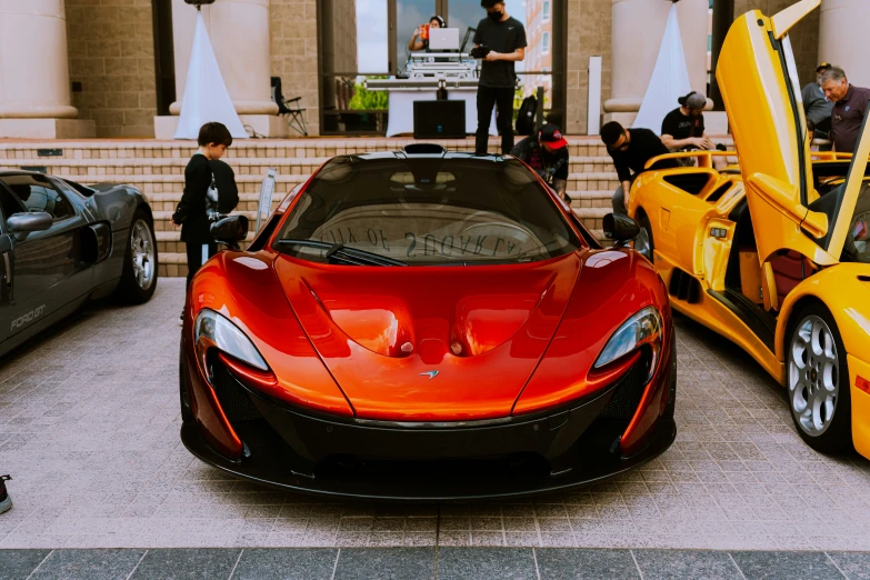 several orange sports cars parked next to each other