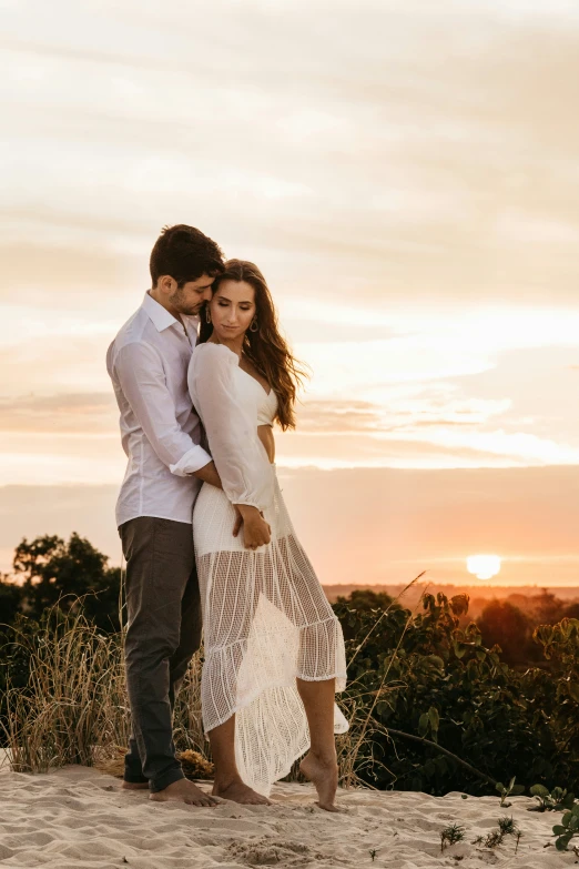 a beautiful young couple emce each other in the desert at sunset