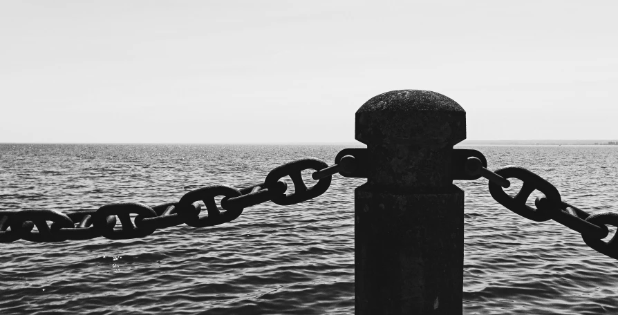 an old fashioned chain hanging over the ocean