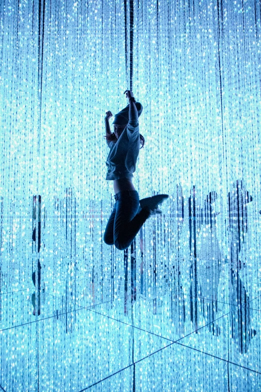 a person suspended from a long curtain in a building