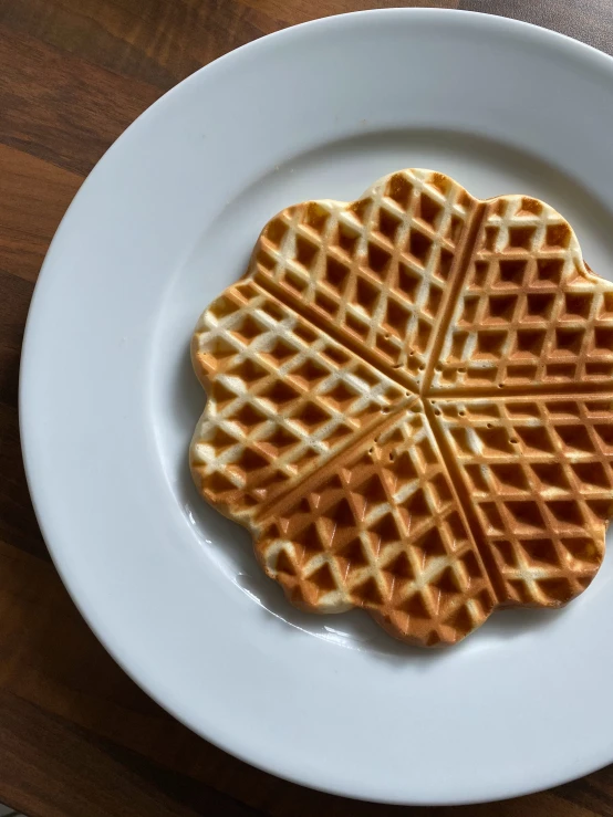 waffles on a white plate on a wood surface