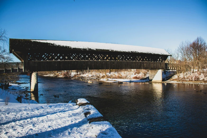 there is snow that is on the ground under a bridge