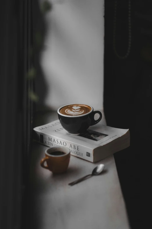 a cup of coffee sitting on top of a book