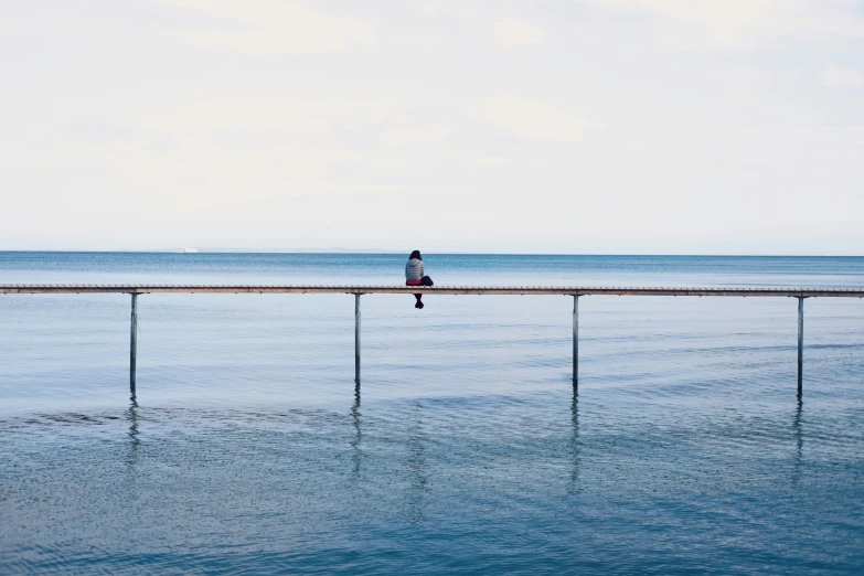 a person is walking across the water on a bridge