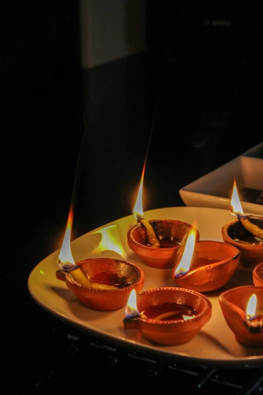 a row of pots filled with lit candles
