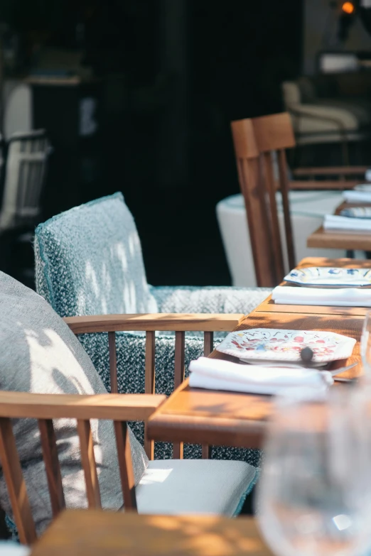 an outdoor table setting with blue and white tablecloth