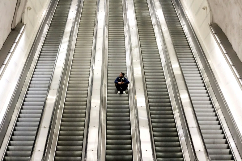 two people sitting on escalators in an airport