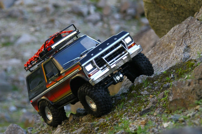 an all terrain truck driving on a rocky hill