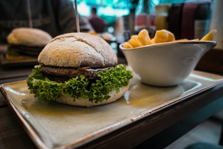 an open faced sandwich on a bun, with a side of fries