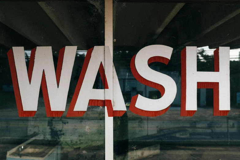the words wash are painted on a window